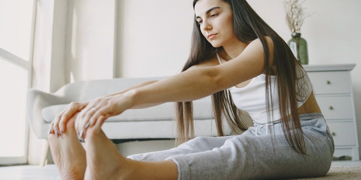 Young woman stretches on a rug in a light-filled room, embracing home fitness.